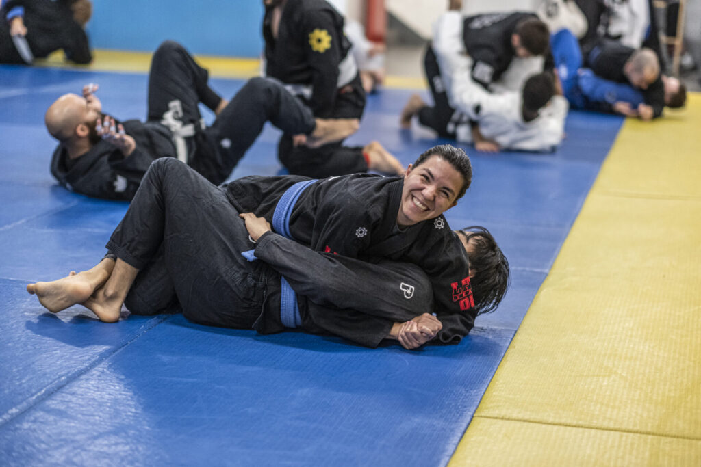 Female BJJ blue belt smiling during sparring at London Fight Factory.