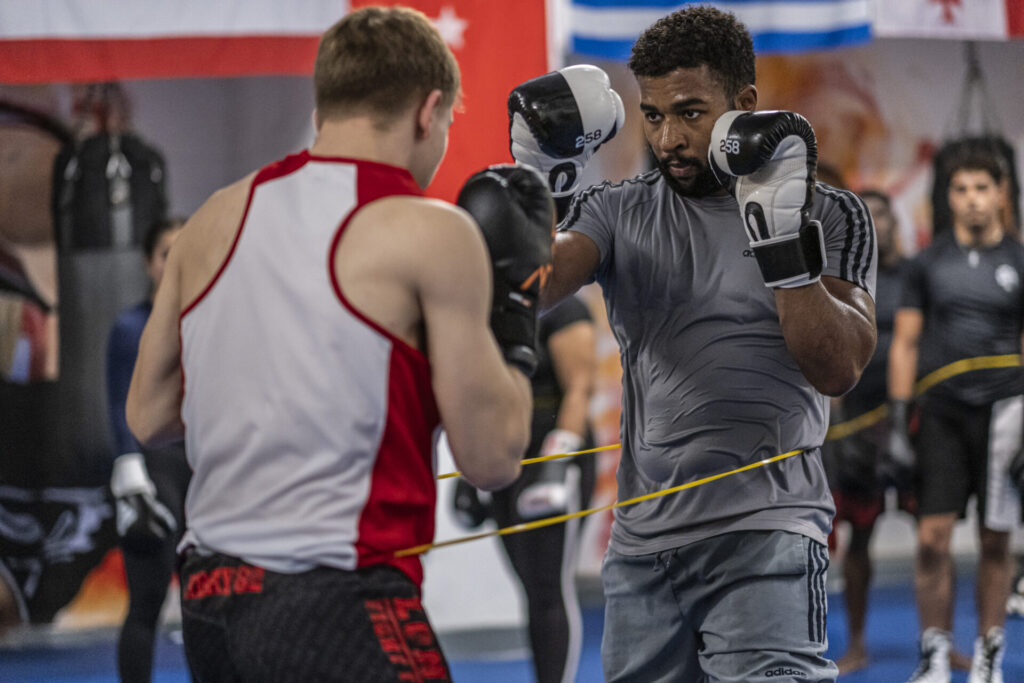 Boxers sparring in the ring at London Fight Factory, focusing on defensive stance.