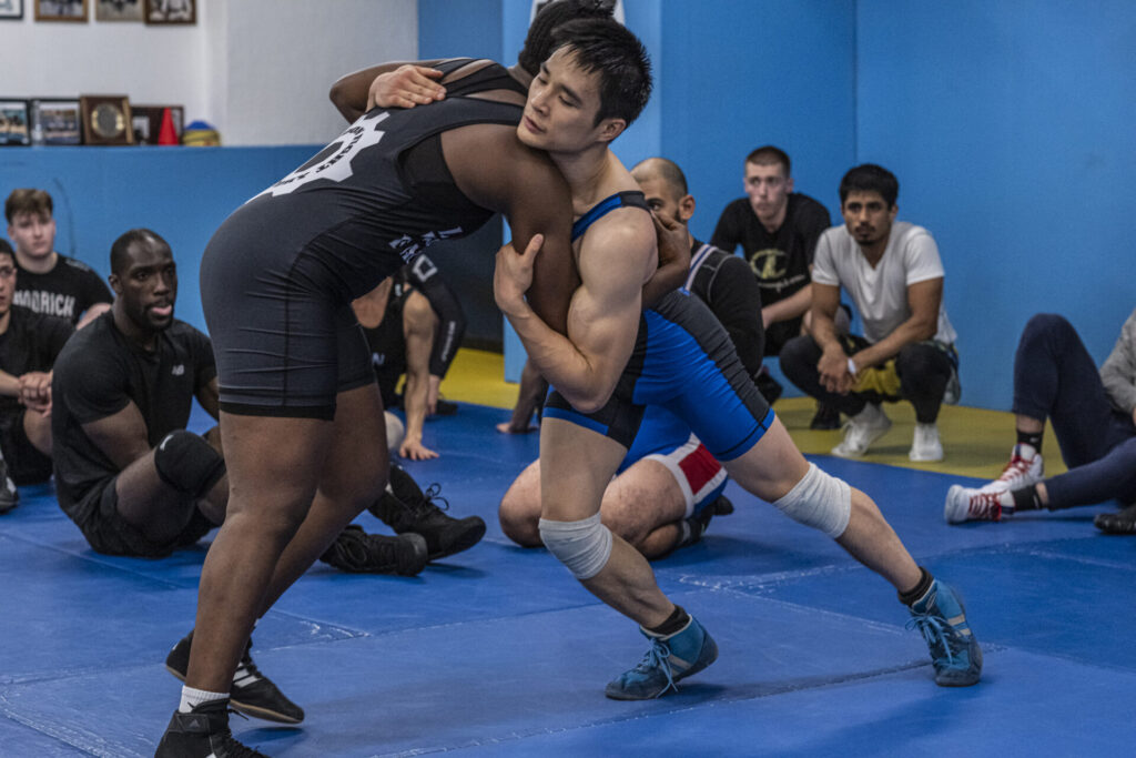 Two wrestlers engaged in a clinch drill during practice at London Fight Factory.